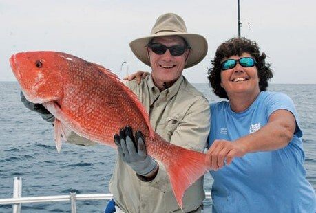 FISHING_IMG_5311 Frank Murray of Atlanta, Georgia and Captain Kathy Brown of Miss Judy Charters definitely have something to smile about….and that is…This nice, big, genuine red snapper, which was caught while bottom fishing at the Savannah Snapper Banks. Photo by Judy Helmey
