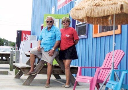 Jim and Evelyn Hobbs outside the the ships store, now sporting a freshly painted, bright exterior and a comfortable area to enjoy the view. 