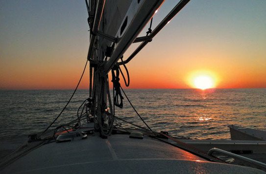 The sun sets off the bows of Tri Dreaming. Photo by Terry Boram