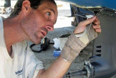 Surgery on the boot of one of the saildrives; Mark is sewing a little rip – a new skill! Photo by Liesbet Collaert