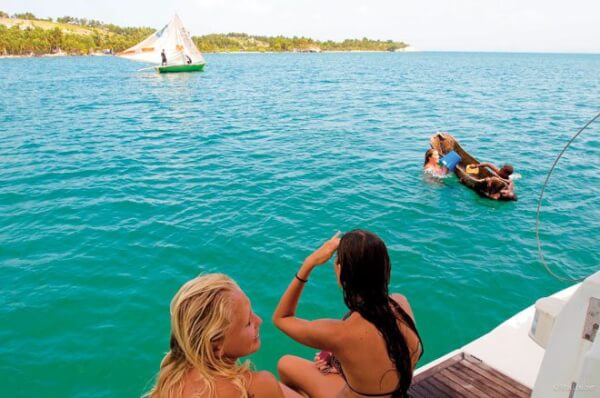 Maria playing with a local child as fisherman sail out the bay. Photo by Captain Max Loubser
