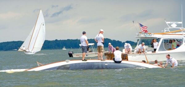 Crew from the log canoe “Magic” prepare to right the boat after capsizing in 2014 Governor’s Cup. PHoto by Shannon Hibberd / www.wanderlustphotog.com