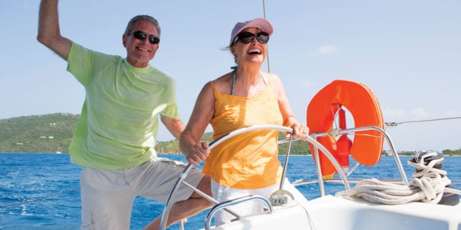 A couple sail their charter boat through the British Virgin Islands. Photo courtesy of the Moorings